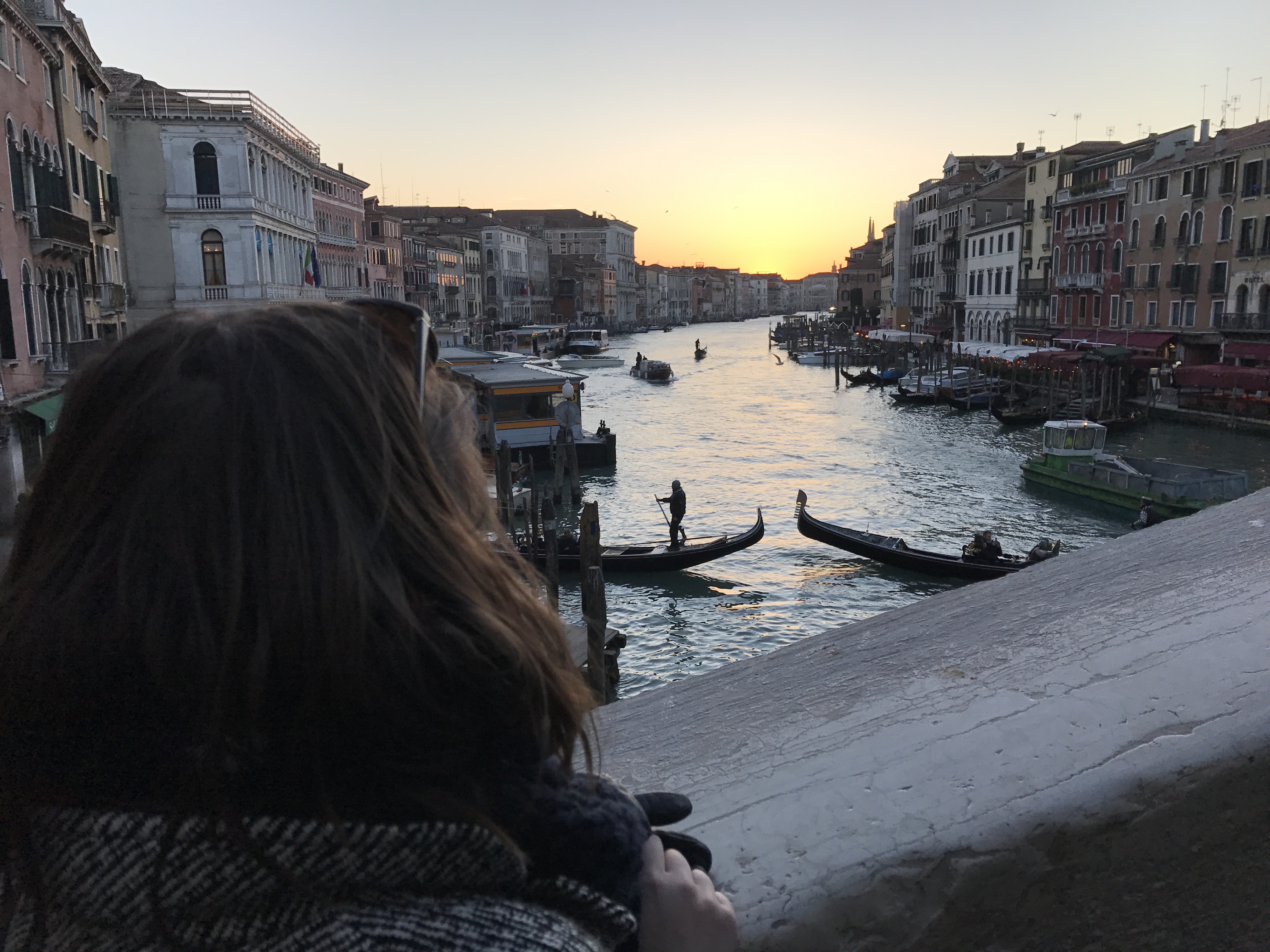 Une personne qui regarde le coucher du soleil sur Venise